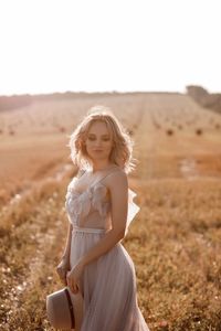 Portrait of smiling young woman sitting on field