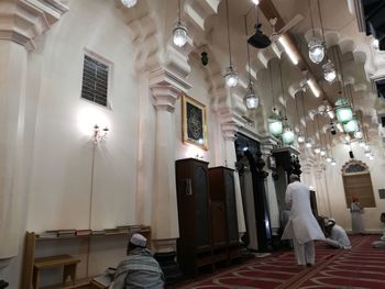 Rear view of people standing in illuminated room