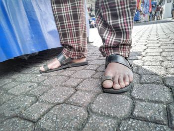 Low section of man standing on footpath