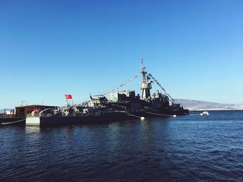 Ship in sea against clear blue sky