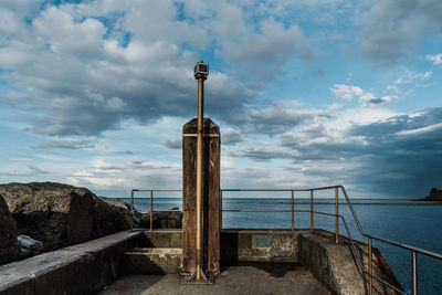 Railing by sea against sky