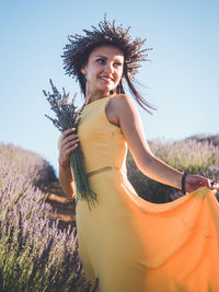 Portrait of young woman standing against sky