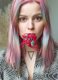 Close-up portrait of woman with threads on mouth