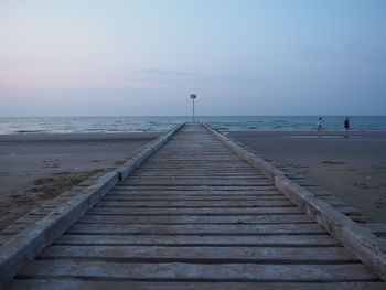 Pier over sea against sky during sunset