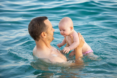 High angle view of father and son in swimming pool