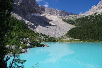 Scenic view of lake and mountains against blue sky