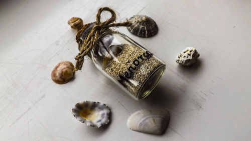 High angle view of spice in bottle amidst seashells on table