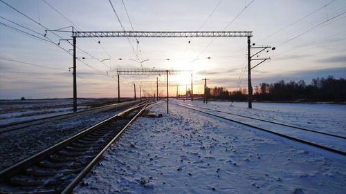 Railroad tracks against sky during winter