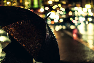 Close-up of wet illuminated street at night