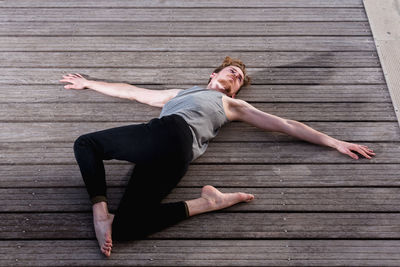 Full length of man lying on wooden floor