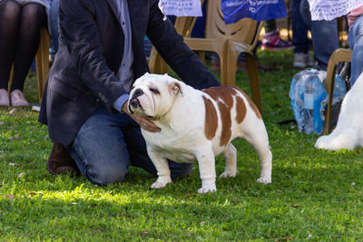 Low section of people with dog on field