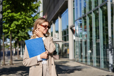 Young woman using mobile phone in city