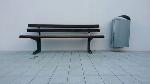 Empty bench against wall