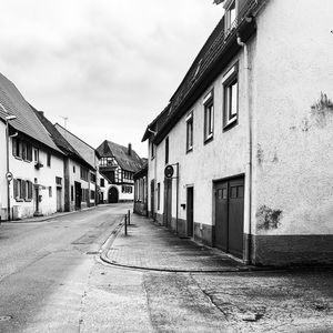 Empty road amidst buildings against sky