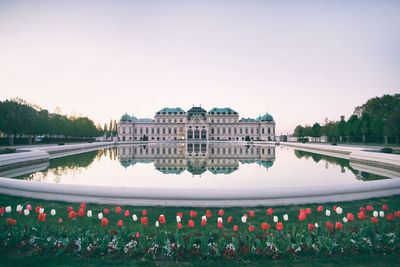 View of building by river against clear sky