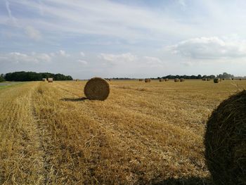 Scenic view of field against cloudy sky