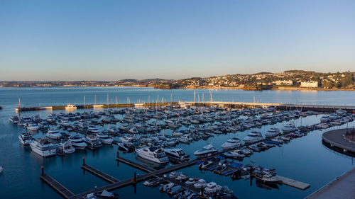 High angle view of harbor by sea against clear sky