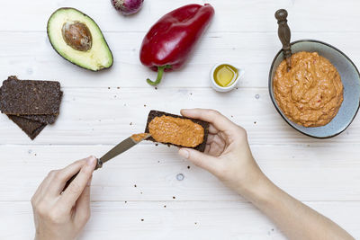 High angle view of hand holding food on table