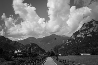 Empty road by mountains against sky