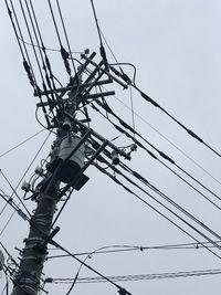 Low angle view of electricity pylon against clear sky