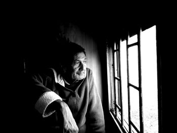 Man looking away while sitting in train by window