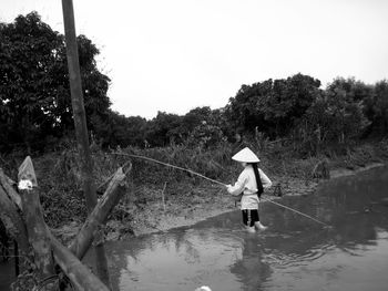Rear view of person walking on umbrella during rainy season
