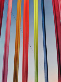 Low angle view of multi colored flags hanging against blue sky