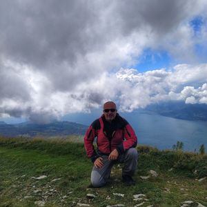 Full length of man sitting on rock against sky