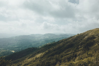 Scenic view of mountains against cloudy sky