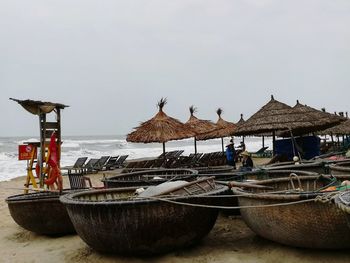 Lounge chairs on beach against clear sky