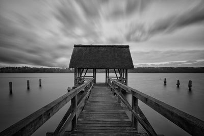 Wooden pier over lake against sky