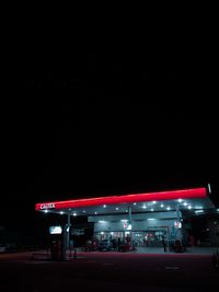 Illuminated light trails on road against sky at night