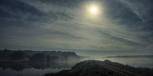 Scenic view of lake against sky during foggy weather