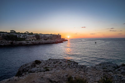 Scenic view of sea against clear sky at sunset