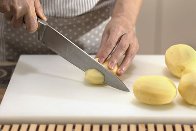 Midsection of person preparing food on cutting board