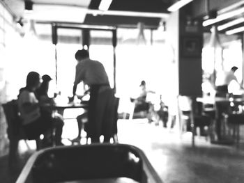 Rear view of people sitting on tiled floor