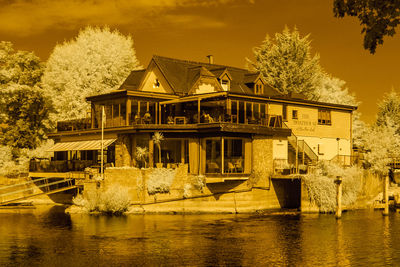 Building by river against sky