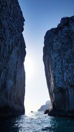 Rock formations in sea against clear sky