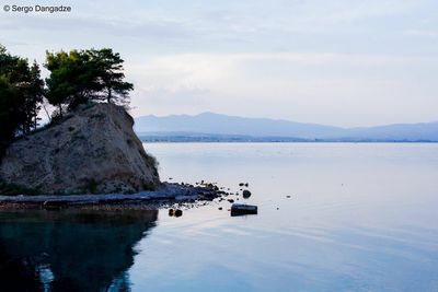 Scenic view of lake by mountain against sky