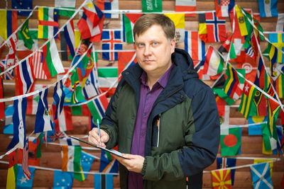 Portrait of man holding multi colored umbrella