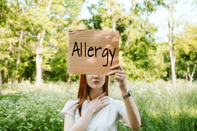 Portrait of woman with text against plants