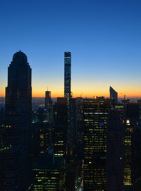 Illuminated buildings against sky during sunset