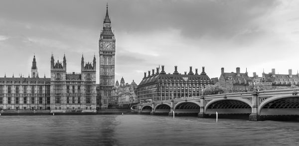 Low angle view of big ben by thames river against sky