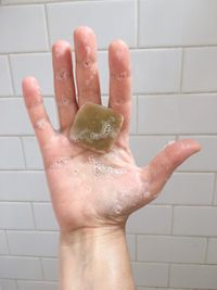 Close-up of wet hand in bathroom