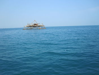 View of boat in sea against clear sky