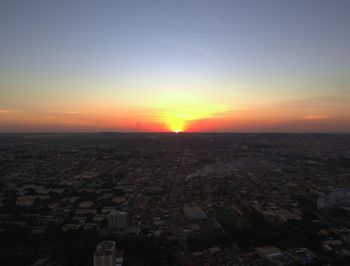 Aerial view of city buildings against sky during sunset