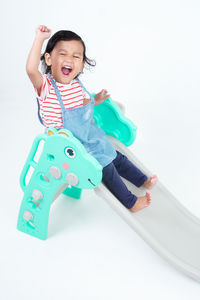 Portrait of cute girl with toy against white background