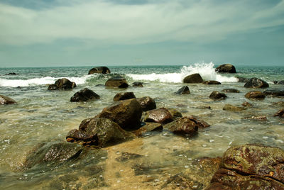 Rocks in sea against sky