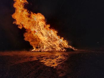 Panoramic view of bonfire on beach at night