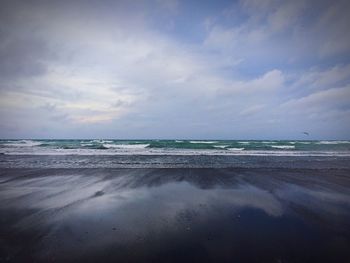 View of beach against cloudy sky